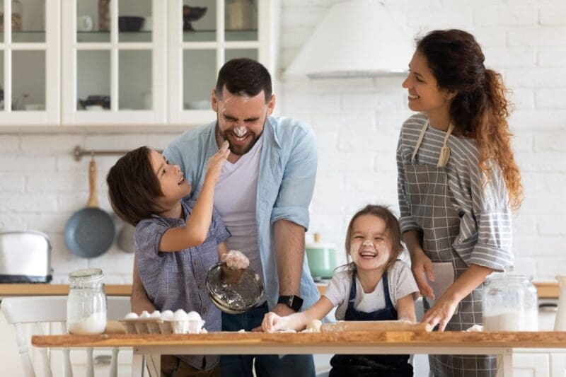 Joyful family baking with flour fun in Nika's stress-free relocation furnished housing.